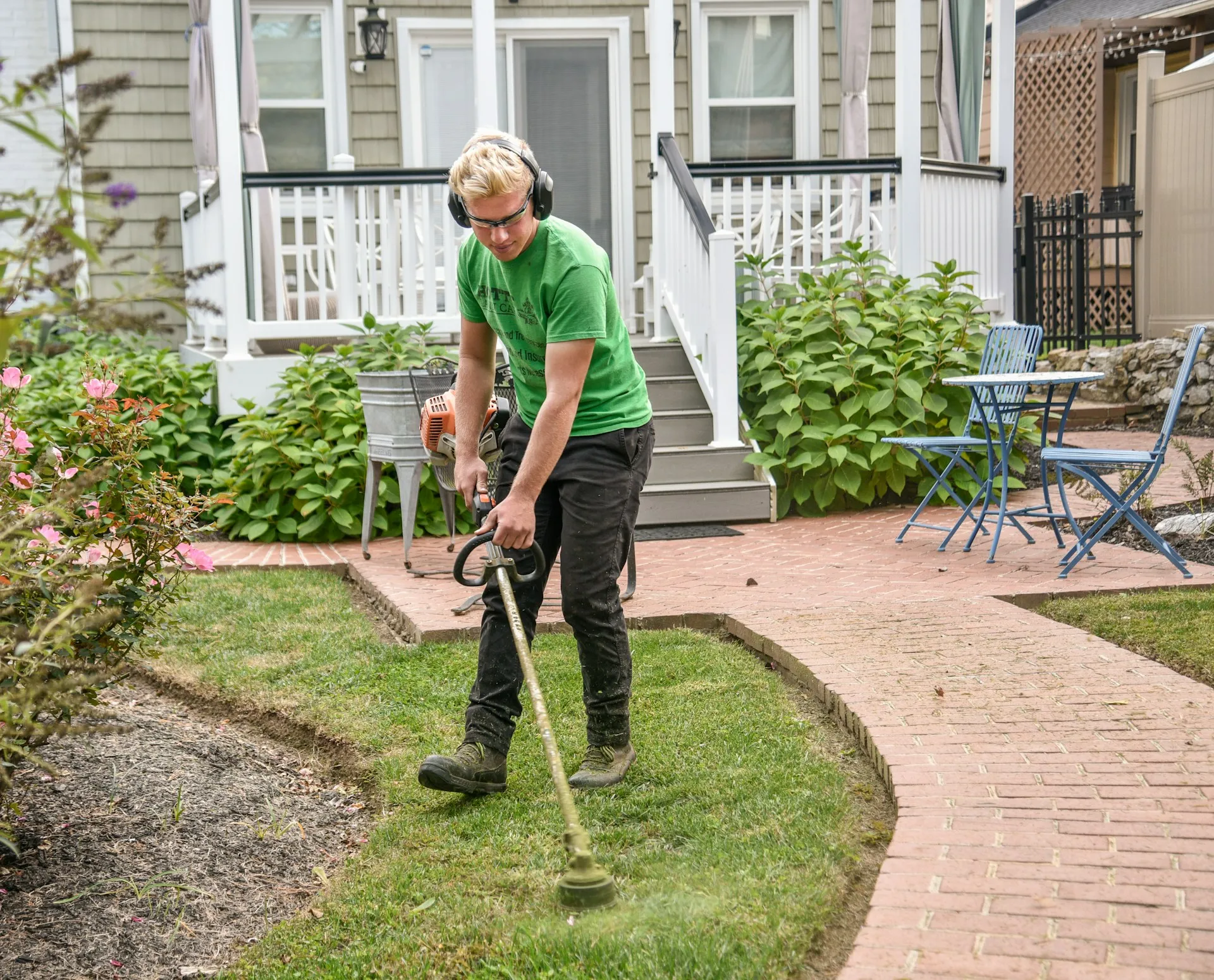 Professional landscaper performing lawn maintenance with a weed wacker